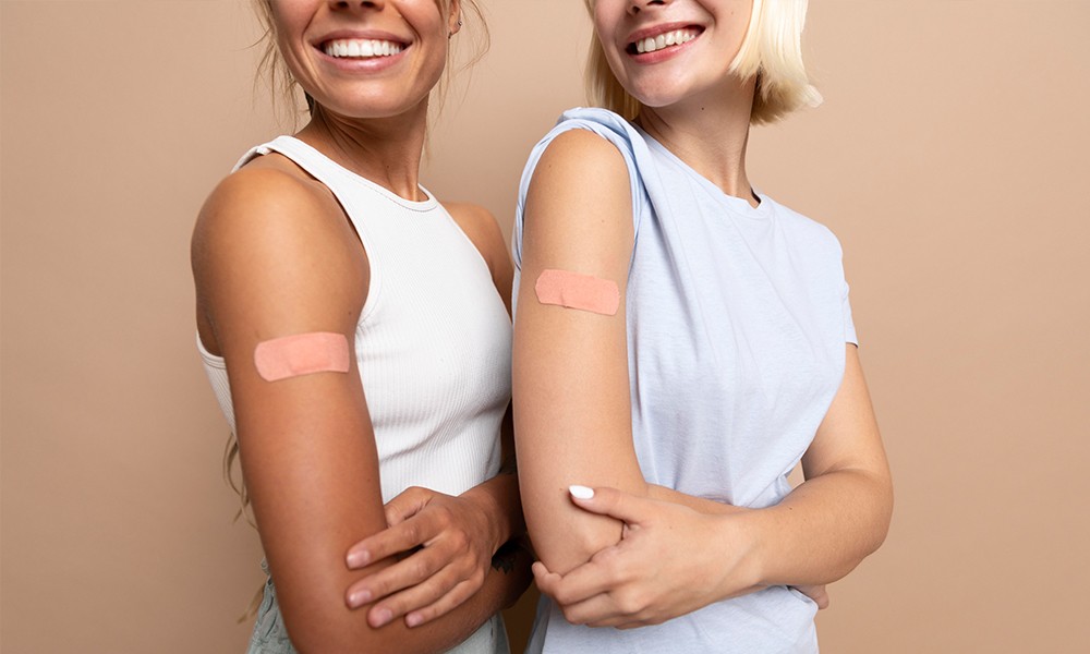 zwei Frauen nach der Impfung mit Pflaster am Arm